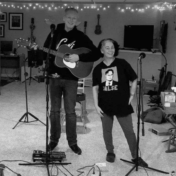 Lela and Dennis Whalen in their basement practice space with guitar and microphones